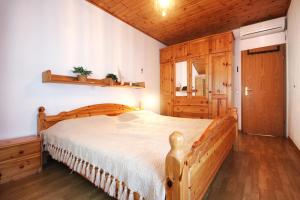 a bedroom with a wooden bed and a wooden cabinet at Apartment Lumbarda 4440f in Lumbarda