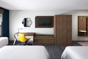 ホリスターにあるHoliday Inn Express & Suites - Hollister, an IHG Hotelのベッド2台、デスク、テレビが備わるホテルルームです。