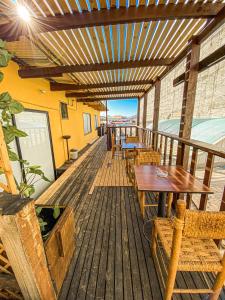 una terraza de madera con mesas y sillas. en Hotel Londres La Serena, en La Serena