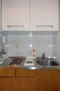 a kitchen counter with a sink and a stove at Apartments and rooms with parking space Nin, Zadar - 5805 in Nin