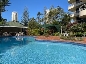 a large swimming pool in front of a building at Capricornia Apartments in Gold Coast