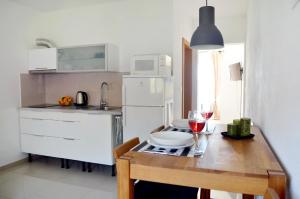 a small kitchen with a wooden table with a glass of wine at Studio Orebic 4563d in Orebić