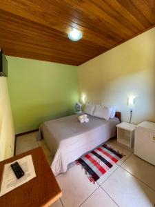 聖佩德羅達塞拉的住宿－Pousada Guimaraes，一间卧室设有一张床和木制天花板