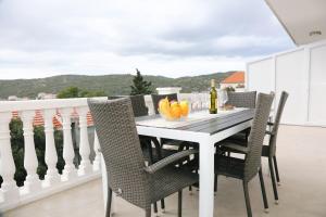 a white dining room table with chairs on a balcony at Apartments with a parking space Zavalatica, Korcula - 4459 in Zavalatica