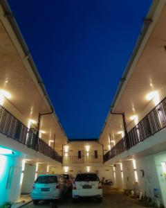 two cars parked in a parking lot at night at RUMAH KOPI SYARIAH HOTEL in Bandar Lampung