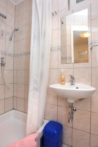 a bathroom with a sink and a shower curtain at Apartments with a parking space Omis - 4327 in Omiš