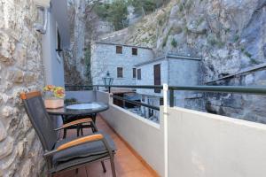 a balcony with two chairs and a table on a wall at Apartments with a parking space Omis - 4327 in Omiš