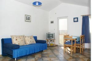 a living room with a blue couch and a table at Apartment Vlasici 4319a in Vlašići