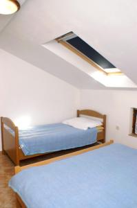 a bedroom with two beds and a skylight at Apartment Vlasici 4319a in Vlašići