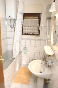 La salle de bains est pourvue d'un lavabo, de toilettes et d'une baignoire. dans l'établissement Apartments with a parking space Podstrana, Split - 4326, à Podstrana