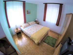 a small bedroom with a bed and two windows at Apartments by the sea Biograd na Moru, Biograd - 4316 in Biograd na Moru