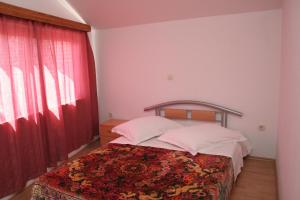 a bedroom with a bed and a red window at Apartments by the sea Brna, Korcula - 4415 in Smokvica