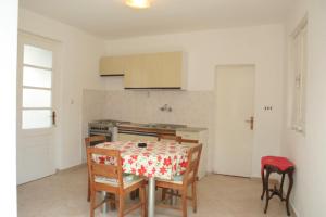 a kitchen with a table and chairs and a kitchen with a stove at Apartments by the sea Brna, Korcula - 4415 in Smokvica