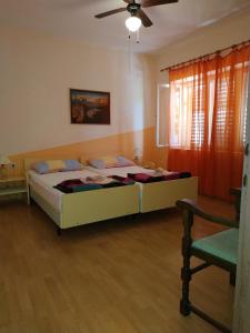 Apartment Brna 4468a في برنا: غرفة نوم بسرير ومروحة سقف