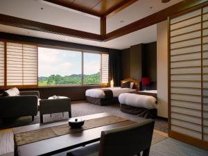 a hotel room with two beds and a large window at Hotel Flags Kuju Kusima in Sasebo