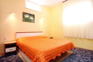 - une chambre avec un lit orange et une fenêtre dans l'établissement Apartments by the sea Racisce, Korcula - 4344, à Račišće