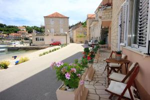 - un balcon fleuri avec une table et des chaises dans l'établissement Apartments by the sea Racisce, Korcula - 4344, à Račišće