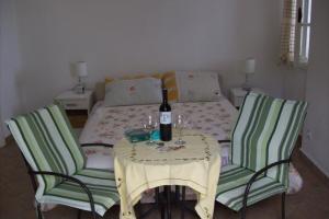 uma mesa com uma garrafa de vinho e duas cadeiras em Apartments by the sea Trpanj, Peljesac - 4549 em Trpanj