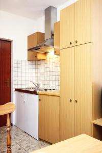 a kitchen with wooden cabinets and a sink at Apartments by the sea Orebic, Peljesac - 4496 in Orebić