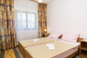 a bedroom with two beds and a window at Apartments by the sea Orebic, Peljesac - 4496 in Orebić