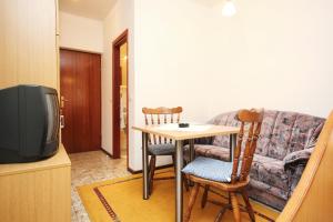 ein Wohnzimmer mit einem Tisch und 2 Stühlen in der Unterkunft Studio Orebic 4496d in Orebić