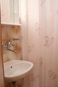 a bathroom with a sink and a shower curtain with butterflies at Studio Trstenik 4566b in Trstenik