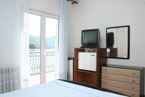 a bedroom with a television and a dresser with a mirror at Double Room Trstenik 4566b in Trstenik
