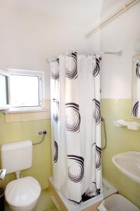 e bagno con servizi igienici e tenda per la doccia. di Apartments and rooms by the sea Orebic, Peljesac - 4517 a Orebić (Sabbioncello)