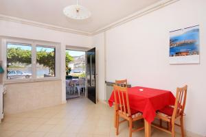 a dining room with a red table and chairs at Apartments by the sea Kneza, Korcula - 4365 in Pupnat
