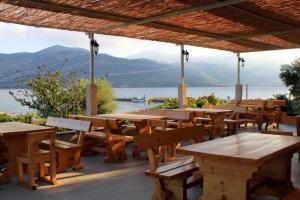 a patio with tables and chairs and a view of the water at Apartments by the sea Kneza, Korcula - 4371 in Pupnat