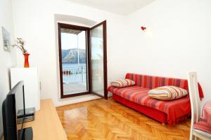 a living room with a red couch and a television at Apartments by the sea Kneza, Korcula - 4371 in Pupnat