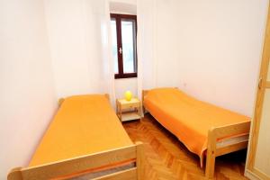 two beds in a small room with a window at Apartments by the sea Kneza, Korcula - 4371 in Pupnat