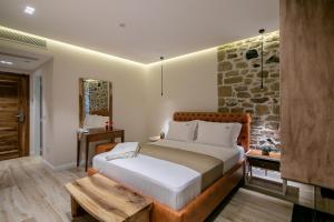 a bedroom with a bed and a stone wall at Vecchia Boutique Hotel in Korçë
