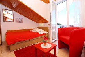 a bedroom with a red bed and a red chair at Apartment Racisce 4360a in Račišće