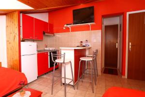 a kitchen with red cabinets and bar stools at Apartment Racisce 4360a in Račišće