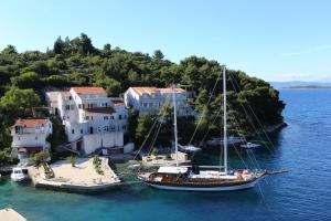 a boat is docked in the water next to a house at Apartment Racisce 4360a in Račišće