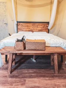 a wooden bench with two baskets on it next to a bed at Woods Inn in Jiaoxi