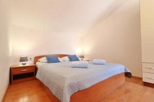 a bedroom with a bed with blue pillows on it at Apartments by the sea Vela Luka, Korcula - 4449 in Vela Luka