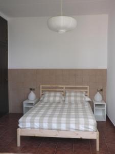 1 dormitorio con 1 cama con 2 mesitas de noche y 2 lámparas en Apartament Can Batlle, en Premiá de Mar