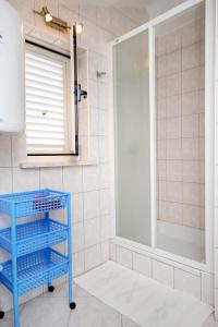 a bathroom with a blue cart in front of a shower at Apartments with a parking space Korcula - 4433 in Korčula