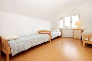 een slaapkamer met 2 bedden en een houten vloer bij Apartments with a parking space Korcula - 4433 in Korčula