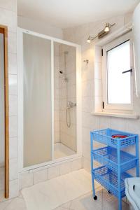 ein Bad mit einer Dusche und einem blauen Korb in der Unterkunft Apartments with a parking space Korcula - 4433 in Korčula
