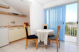 eine Küche mit einem Tisch und Stühlen sowie einen Balkon in der Unterkunft Apartments with a parking space Korcula - 4433 in Korčula