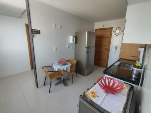 瓜拉帕里的住宿－Praia do Morro Frente para o Mar，厨房配有桌子和不锈钢冰箱。