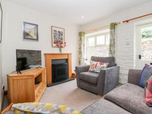 a living room with a couch and a television at Kings Studio in Reeth