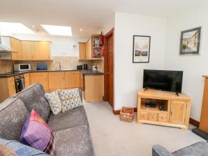 a living room with a couch and a flat screen tv at Kings Studio in Reeth