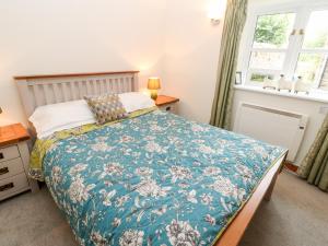 a bedroom with a bed with a blue comforter at Kings Studio in Reeth