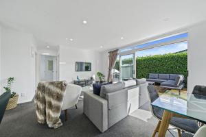 a living room with a couch and a table at Treasure on Tuscan - Martinborough Holiday Home in Martinborough