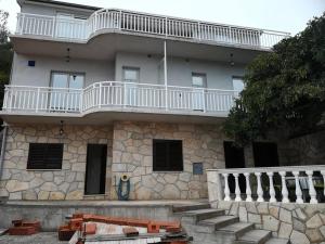 un bâtiment avec un balcon au-dessus dans l'établissement Apartments by the sea Grscica, Korcula - 4487, à Prižba