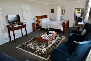 een woonkamer met een bed, een bank en een tafel bij The Loft Bed and Breakfast in Taupo